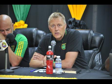 Reggae Boyz head coach Heimir Hallgrimsson (right) speaks during a press briefing to announce a squad for upcoming matches in the Concacaf Nations League at the Jamaica Football Federation head office in New Kingston yesterday. At left is assistant coach J