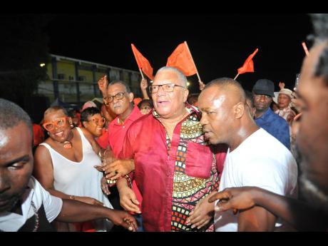 PNP supporters swarm Dr Peter Phillips, former president of the party, on his arrival for the East Central St Andrew Annual Constituency Conference at Jacisera Park.