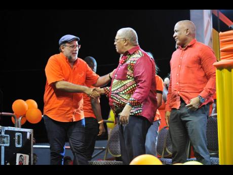 From left: Opposition Leader Mark Golding greets his predecessor Dr Peter Phillips as Dr Ernest Hilaire, deputy prime minister of St Lucia, looks on during the East Central St Andrew Annual Constituency Conference at Jacisera Park.