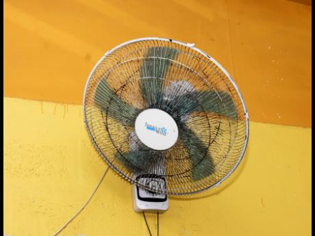 A rusty wall-mounted fan cools a classroom at the Farm Primary and Infant school on Monday.