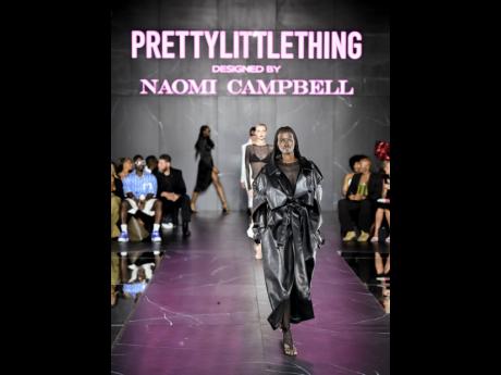 A model walks the runway in a black PU oversized trench. 