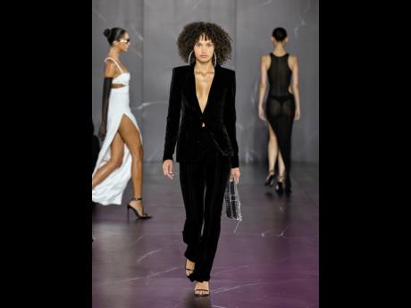 The line also featured sleek pantsuits. This model wears a fitted velvet blazer and flared trousers.