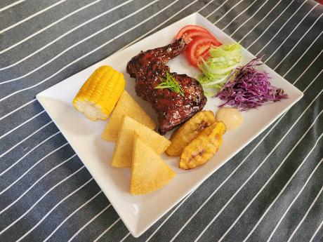 Jamaican favourite, jerk chicken, is served with sweet corn, bammy and vegetables.