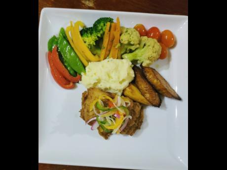 Seafood lovers can dive right into this escoveitch fish fillet with steamed vegetables, cream potatoes and ripe plantains.