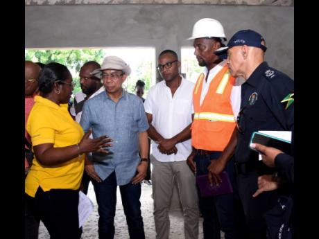 Dr Horace Chang (centre), minister of national security, listens to Jacqueline Johnson (left), senior project manager, special projects unit at the National Housing Trust, while Morland Wilson (third right), member of parliament, Westmoreland Western; Marl