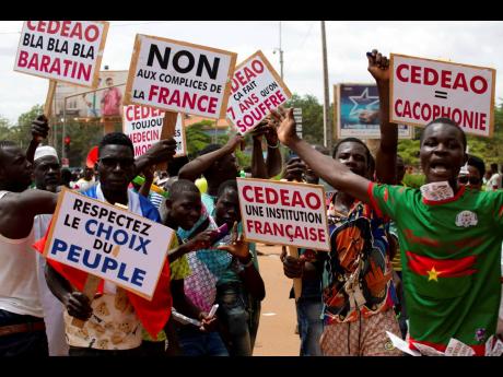 Supporters of Captain Ibrahim Traore protest against France and the West African regional bloc ECOWAS in the streets of Ouagadougou, Burkina Faso, in October 2022. 