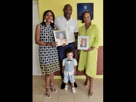 Daughter Kim Richards (left), son Richard Watson (second left), grandson Edgar Watson (second right),  and daughter Dr Jacqueline Watson (right), director of the Watson Family RalRosa Foundation, pose with pictures of Keith and Phyllis Watson, during an of