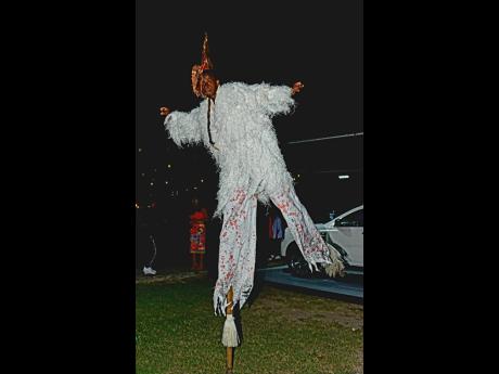 The 12-foot tall Jonkonnu stilt-walker kept dancing in order to maintain his balance.