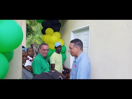 New homeowner Leroy Grant (second right) with Prime Minister Andrew Holness (right) and West Portland Member of Parliament Daryl Vaz.