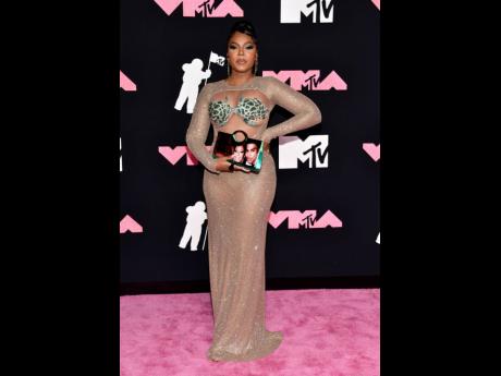 Ashanti arrives at the MTV Video Music Awards on Tuesday, carrying a purse with a throwback photo of herself and Nelly, confirming their rekindled romance.