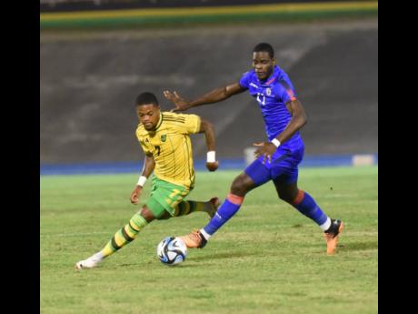 Jamaica’s Leon Bailey (left) changes direction ahead of Haiti’s Mondy Prunier during their Group B Concacaf Nations League A football game at the National Stadium on Tuesday.