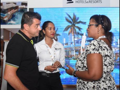 From left: Princess Hotels & Resorts’ Marc Pelfort, Kareen Hall, regional director, sales and marketing, and Michelle Gay, sales and marketing director, American Airlines Vacations, hold a discussion at their exhibition booth at the Jamaica Product Excha