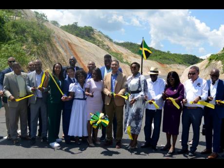 Prime Minister Andrew Holness (centre) is joined by other members of parliament and officials in cutting the ribbon officially to open the lasted completed leg of Highway 2000, which runs from May Pen, Clarendon, to Williamsfield, Manchester, on Thursday.