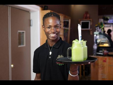 Assistant chef Denzel Harvey serves up two mason jars of Tea Tree Crêperie’s flagship beverage, the frozen mint lemonade. 