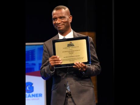 Dr Asburn Pinnock, president of The Mico University College, beams with pride as he collects the institution’s Platinum award.