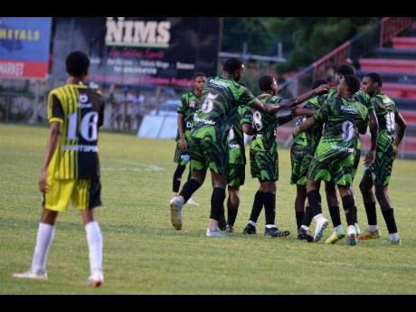 Calabar High School players (right) celebrate one of three goals against Charlie Smith during an ISSA Manning Cup encounter at the Anthony Spaulding Sports Complex yesterday.