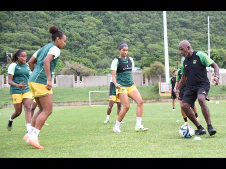 Head coach Lorne Donaldson (right) and the Reggae Girlz squad at their final training session at the Stadium East field yesterday, ahead of today’s big Olympic Games qualifier against Canada at the National Stadium.