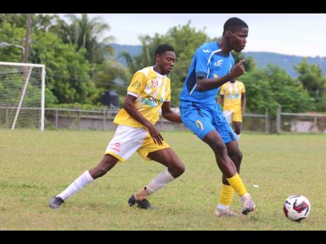 Clarendon College’s Jahmelle Ashley (right)  turns away from Claude McKay High’s Shevar Richardson during their ISSA/WATA daCosta Cup encounter at Effortville on Wednesday.
