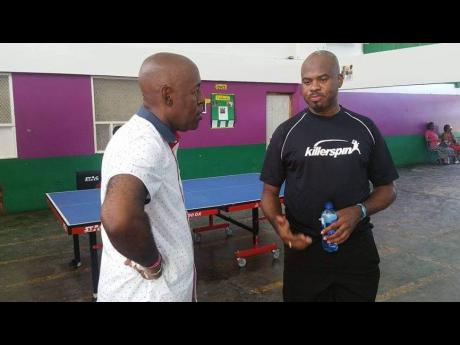 Courtney Wilson (left) talks table tennis with fellow national champion Chris Marsh at a 2017 Heroes Day tournament at William Knibb Memorial High School.