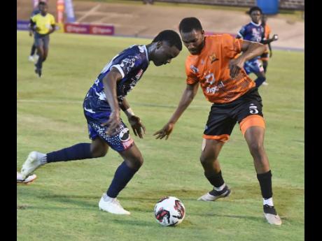 Giovanni Taylor (left) of Jamaica College tries to beat Daeshawn Tate (right) of Tivoli High during the opening match of the 2023 Manning Cup football season. The game was played  at the National Stadium. Ian Allen/Photographer
