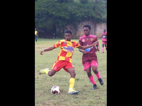 Cornwall College’s O’Brien Bowen (left) battles the ball with Spot Valley High’s Nicholas Heaven during the ISSA/daCosta Cup match at the Cornwall College Sports Complex yesterday. Cornwall won 4-0