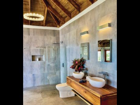 A floor-to-ceiling porcelain-clad bathroom with twin vessel vanity sinks.