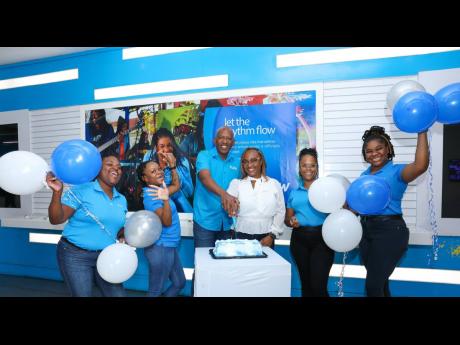 Jodi-Ann Richards (third right), the first Flow customer to be designated the 658 area code, is warmly welcomed by Flow team members at the Carlton store on Half-Way Tree Road in St Andrew on Friday. With Richards (from left) are Donna Allison, retail stor