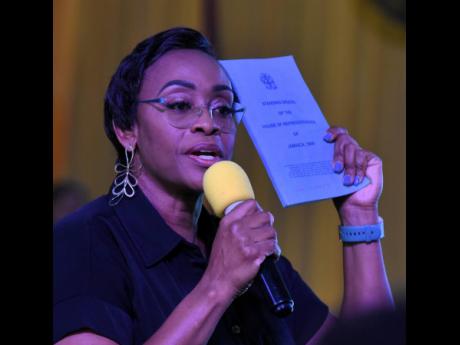Juliet Holness, chairman of a joint select committee of Parliament considering job description, codes of conduct and performance standards for parliamentarians, refers to a copy of the Standing Orders of the Houses of Parliament while addressing members of