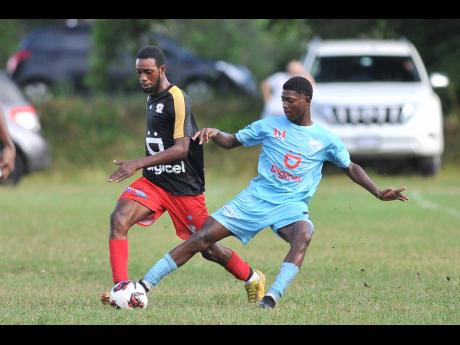 Ronaldo Stewart (right) of St Catherine High steals the ball from Stevaughn Johnson of Mona High during their Manning Cup match at Mona High School last Saturday. Mona won 2-1.