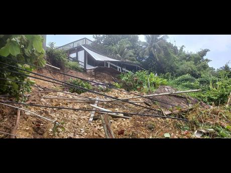 A section of a house in Dolphin’s Bay, Portland, is damaged due to land slippage caused by torrential rains in the parish.