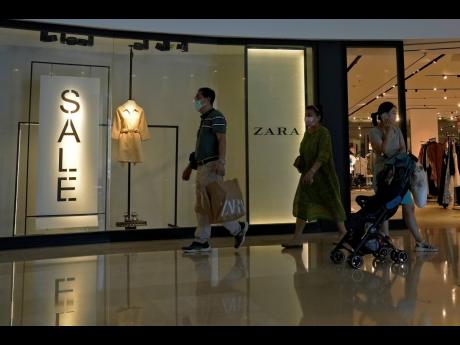 A man with a shopping bag walks out from a ZARA flagship store at a shopping mall in Beijing, on June 21, 2023.