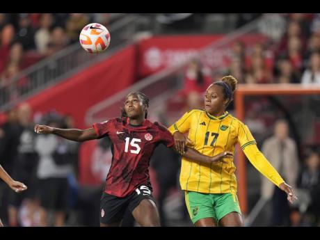 Canada’s Nichelle Prince (left) and Jamaica’s Allyson Swaby vie for the ball during the first half of the second leg of a Concacaf Olympic qualification tie in Toronto yesterday. 