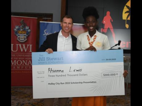 Adam Stewart (left), executive chairman of Sandals Resorts International, presents the Jill Stewart Sports Scholarship to Rhianna Lewis, a 15-year-old student of Rhodes Hall High School in Hanover, during the MoBay City Run Scholarship presentation ceremon