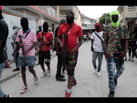Armed members of ‘G9 and Family’ march in a protest against Haitian Prime Minister Ariel Henry in Port-au-Prince, Haiti on September 19.