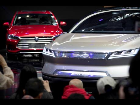 Attendees take photos of the E-SEED electric concept car during a press conference by Chinese automaker BYD at the China Auto Show in Beijing, on April 25, 2018. China’s Commerce Ministry has protested a decision by the European Union to investigate expo