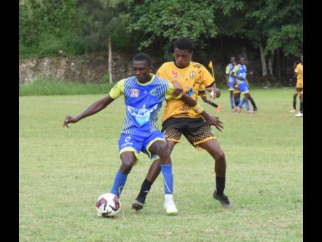 
Cedric Titus High School’s Rashaun Small (left), shields the ball from York Castle’s Deshawn Bentley during an ISSA/WATA daCosta Cup football match at the York Castle High Sports Complex in St Ann yesterday.