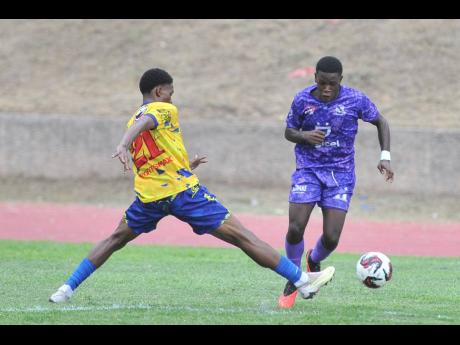 Dontay Stewart (left) of Hydel High tackles Kingston College’s Alex Hislop during a Manning Cup at  the Stadium East field on October 3, 2023. Lightning forced officials to abandon the match after 30 minutes.