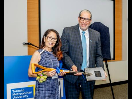 Donette Chin-Loy Chang and Mohamed Lachemi, president and vice-chancellor of Toronto Metropolitan University, with the shovel that the late G. Raymong Chang used 20 years ago to break ground for The G. Raymond Chang School of Continuing Education.