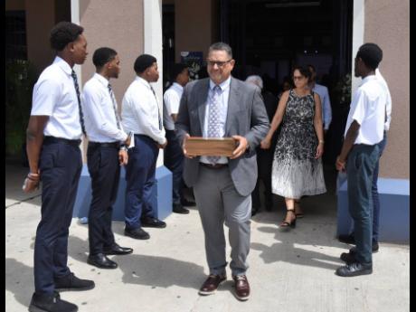 Danny Williams’ family, led by son Ray Williams, carrying his remains from the Karl Hendrickson Auditorium at Jamaica College shortly after his memorial service yesterday.