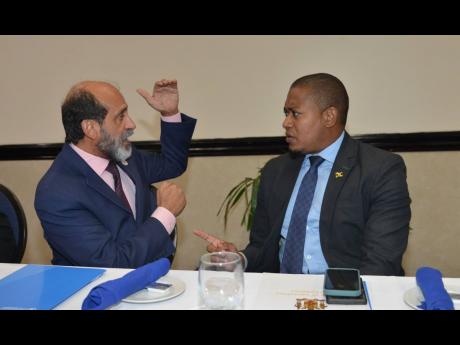 Dr Crispim Moreira, FAO representative for Jamaica, The Bahamas and Belize, speaks with Floyd Green, minister of agriculture, fisheries and mining, during the Improving Rural Livelihoods through Resilient Agrifood Systems launch, at The Jamaica Pegasus hot