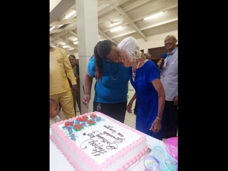 Great-grandson Stewart Bryan plants a kiss on Sybil Robinson at her 100th birthday party.