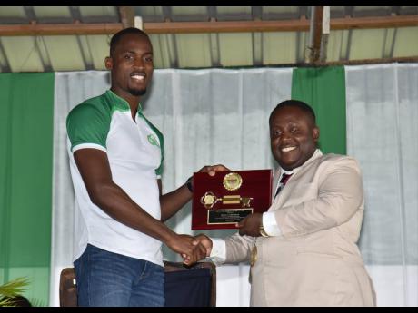 Morant Bay Mayor Hubert Williams (right) presents the key to the township of Morant Bay to Olympian Hansle Parchment during a ceremony in Morant Bay, St Thomas, on Monday.