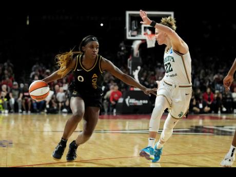 Las Vegas Aces guard Jackie Young (left) drives against New York Liberty guard Courtney Vandersloot during the second half of Game 1 of a WNBA basketball final playoff series on Sunday, October. 8, 2023, in Las Vegas.
