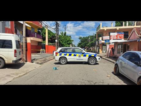 Scene on Young Street in Spanish Town, St Catherine, yesterday, where two men were shot and killed.