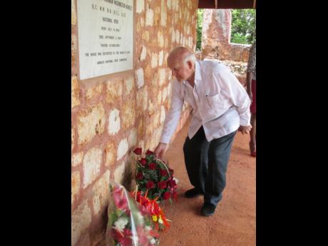 Ainsley Henriques of the Norman Manley Foundation lays a wreath below a plaque at the birthplace of National Hero Norman Manley in Roxborough, Manchester on the occasion of the observance of the 125th anniversary of his birth in 2018.