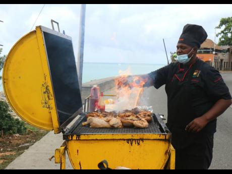 In this April 2021 Gleaner file photo, Dwayne Senior prepares pan chicken on Jimmy Cliff Boulevard in Montego Bay, St James. The St James Municipal Corporation will be rolling out a Safe Food Programme in the Second City by the end of the year.