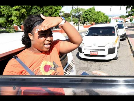 S. Pinnock, university student, speaks with The Gleaner on the first day of fare increases in downtown Kingston, yesterday. 