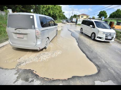 Motorists travelling along the pothole-riddled Lyssons main road in St Thomas last Thursday.
