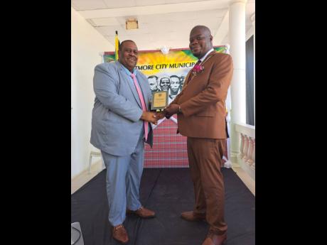 Deputy Mayor of Portmore Alric Campbell (right) receives his plaque from former Mayor Keith Hinds during Monday’s civic and awards ceremony in the municipality. 