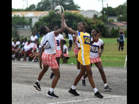 From left: Campion College’s Daneilia Willis battles with St Hugh’s goal keeper Samoya Armstrong during an ISSA Schoolgirls netball game at the St Hugh’s High School yesterday.